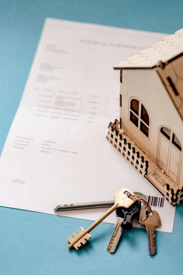 Titre foncier au Togo : maquette de maison, clés et document de propriété