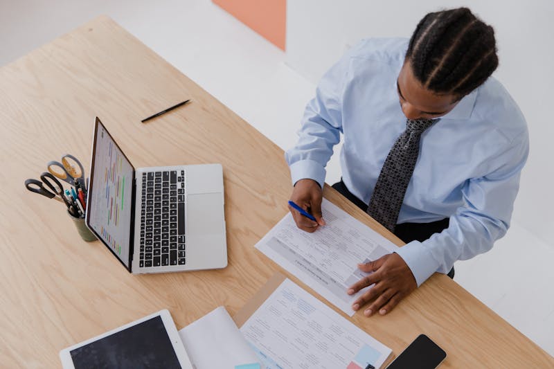 Homme africain redigeant une plainte sur des documents officiels au bureau