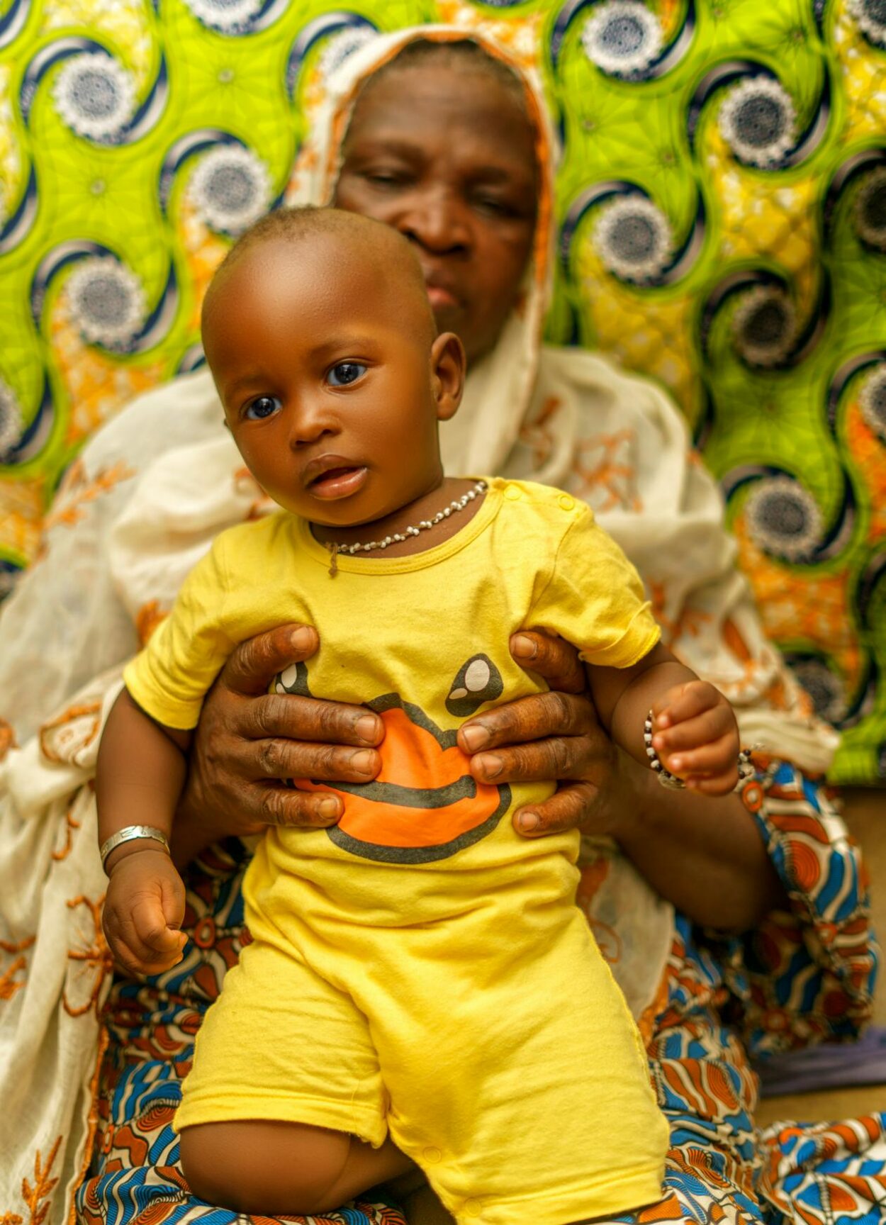 Confiage enfant famille Togo - femme africaine avec bebe sur tissu wax