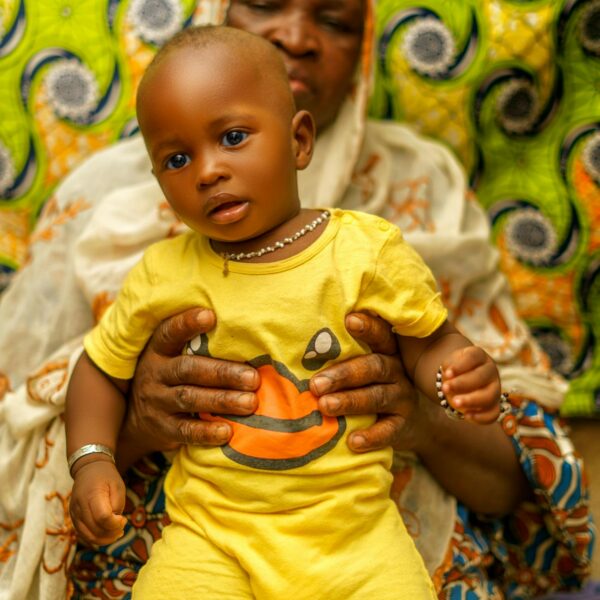 Confiage enfant famille Togo - femme africaine avec bebe sur tissu wax