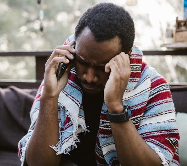 Menaces Facebook Togo - homme inquiet au téléphone victime de cyberharcèlement