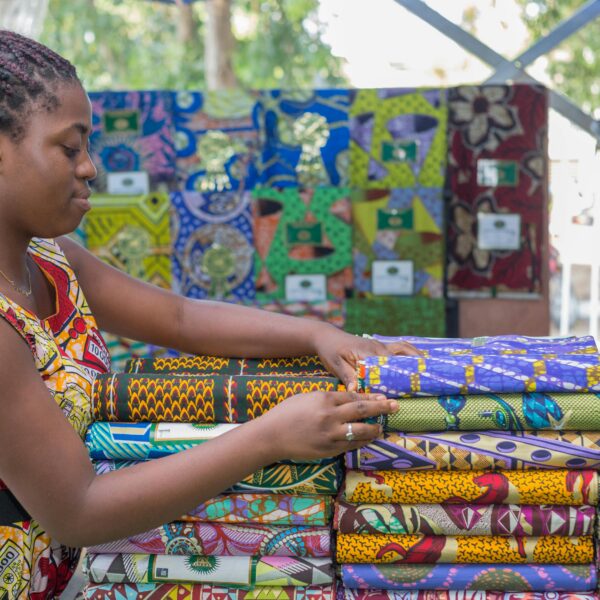 Contrôle OTR Togo : commerçante africaine dans sa boutique de tissus pagne wax face à un contrôle fiscal