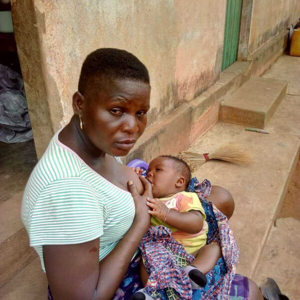 employée de maison Togo gardant un enfant avec un balai au domicile