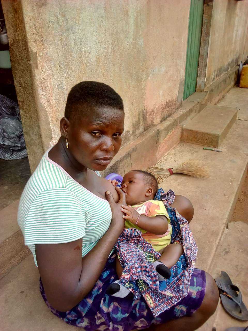 employée de maison Togo gardant un enfant, un balai au domicile