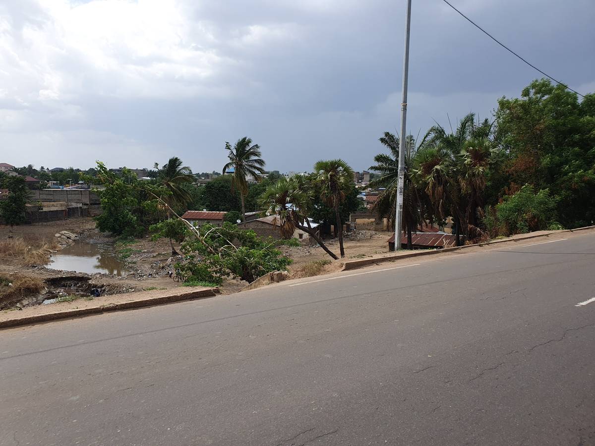 Terrain et habitations le long d'une route au Togo, zone concernée par une expropriation pour utilité publique