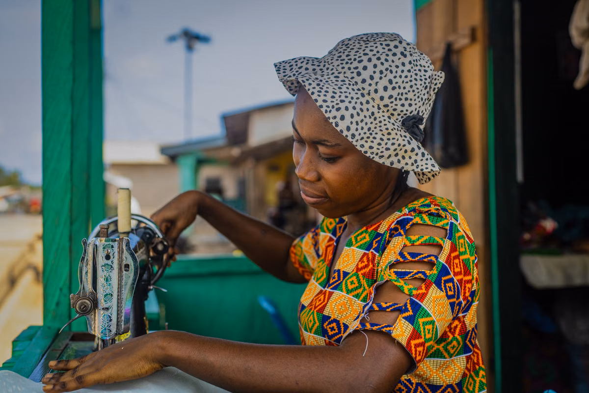 Chèque sans provision au Togo : couturière travaillant à sa machine à coudre dans son atelier
