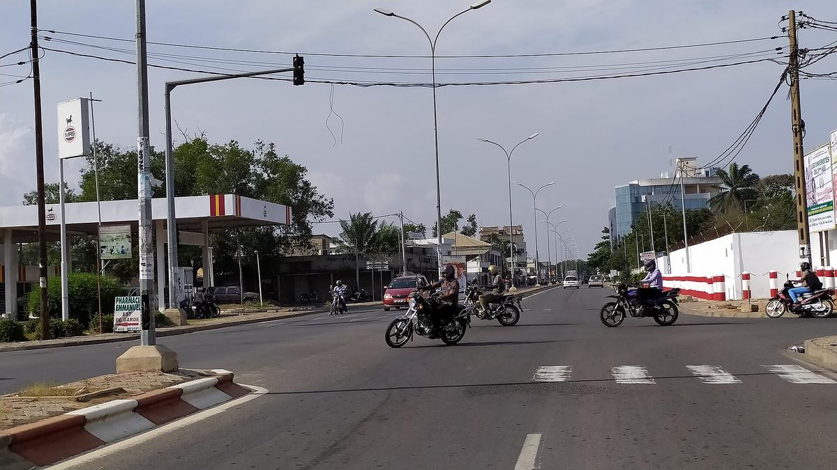 Permis de conduire au Togo : motos et voiture à un carrefour à feux de Lomé