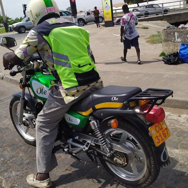 Permis de conduire au Togo : conducteur de moto-taxi casqué sur sa moto immatriculée, à Lomé