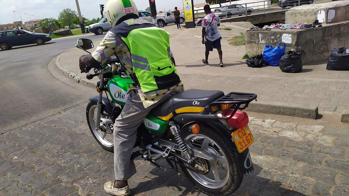 Permis de conduire au Togo : conducteur de moto-taxi casqué sur sa moto immatriculée, à Lomé
