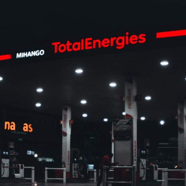 Travail de nuit au Togo : station-service éclairée la nuit, un pompiste au travail à la pompe