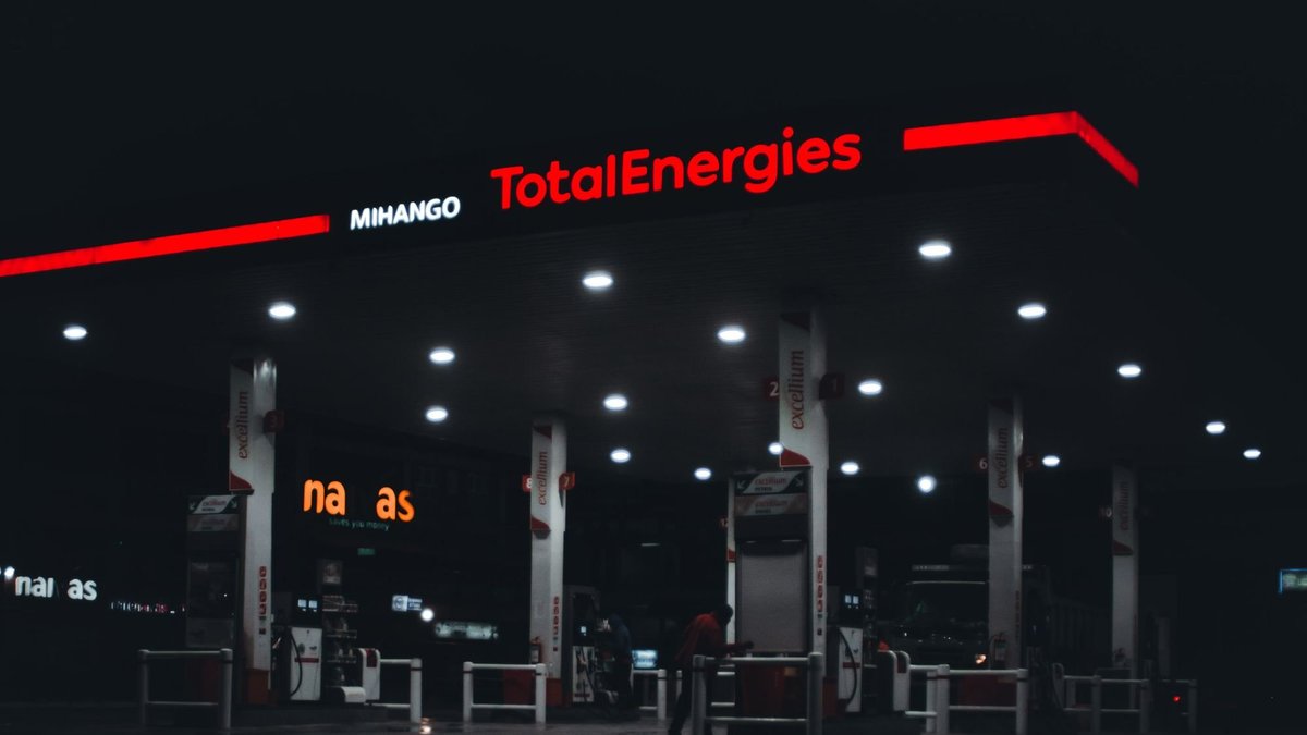 Travail de nuit au Togo : station-service éclairée la nuit, un pompiste au travail à la pompe