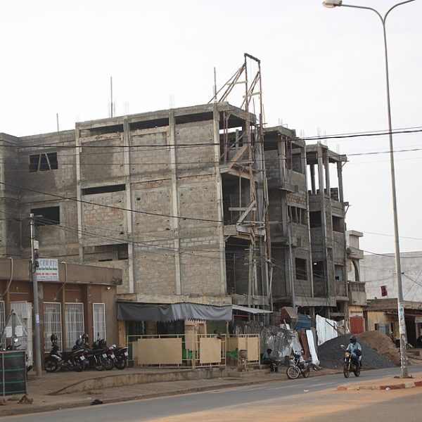 Étranger qui achète un terrain au Togo : immeuble en construction au bord d'une rue de Lomé