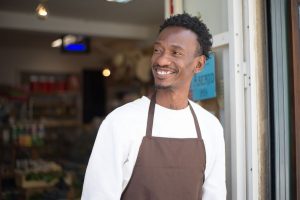 Fonds de commerce au Togo - commerçant africain souriant sur le seuil de sa boutique