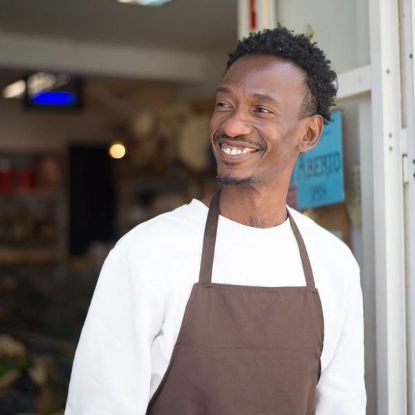 Fonds de commerce au Togo - commerçant africain souriant sur le seuil de sa boutique