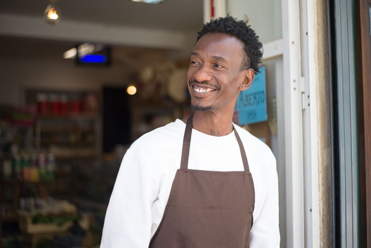 Fonds de commerce au Togo - commerçant africain souriant sur le seuil de sa boutique