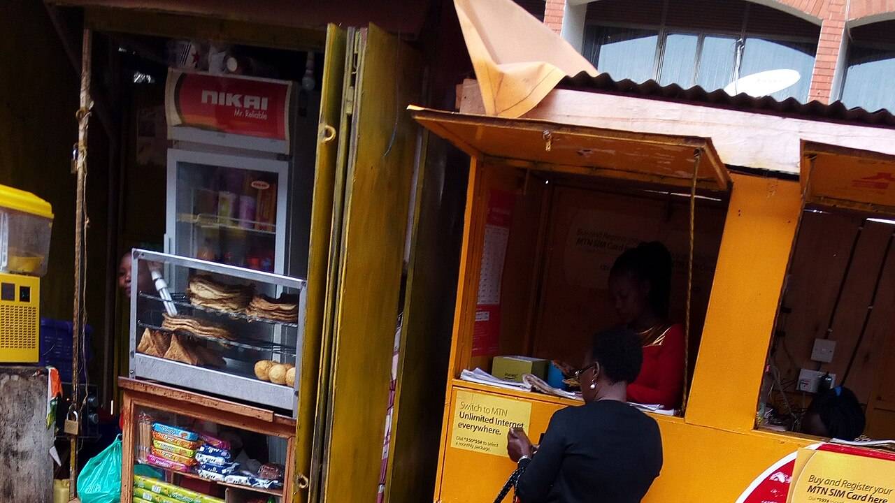 Frais mobile money UEMOA - cliente devant un kiosque de mobile money en Afrique de l'Ouest