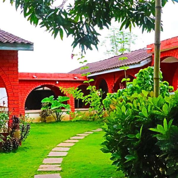Testament au Togo : maison en briques rouges à arcades et son jardin à Kpalimé