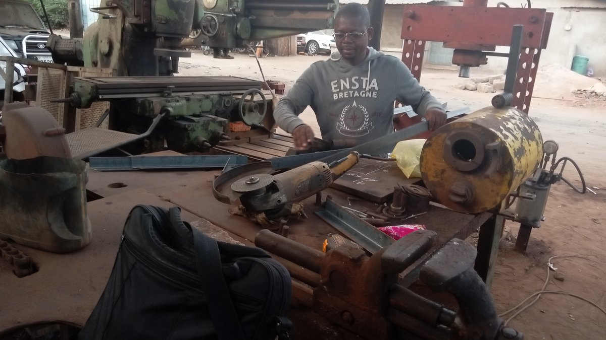 TPU au Togo : artisan au travail dans un atelier de chaudronnerie équipé de machines à Lomé
